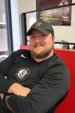 a man with a beard and hat sitting in a chair